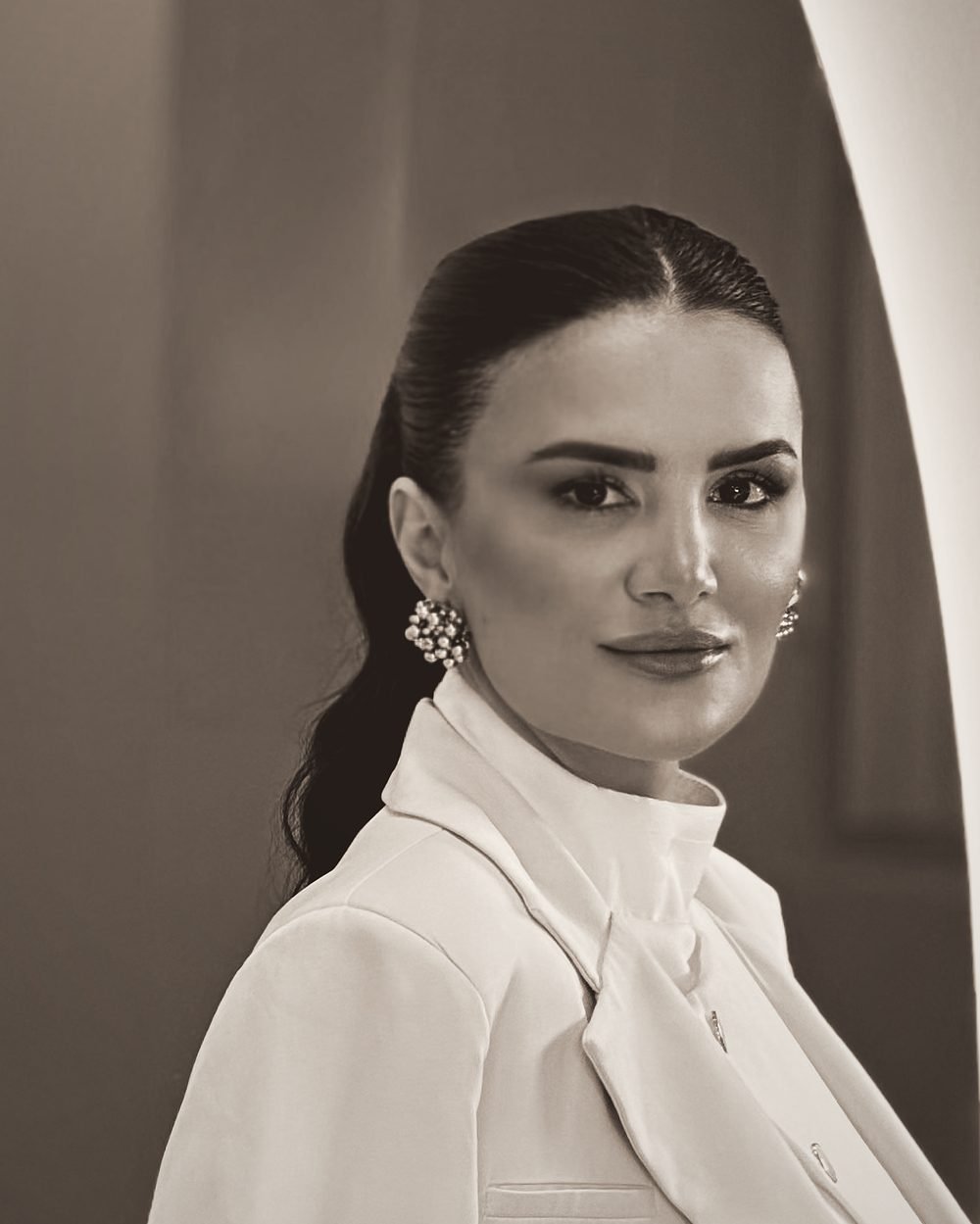 Retrato em preto e branco da Dra. Lais Bueno de jaleco branco